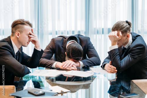 business failure. prospective bankruptcy. stressed stunned crushed defeated team of company executives or managers sit in the boarding room
