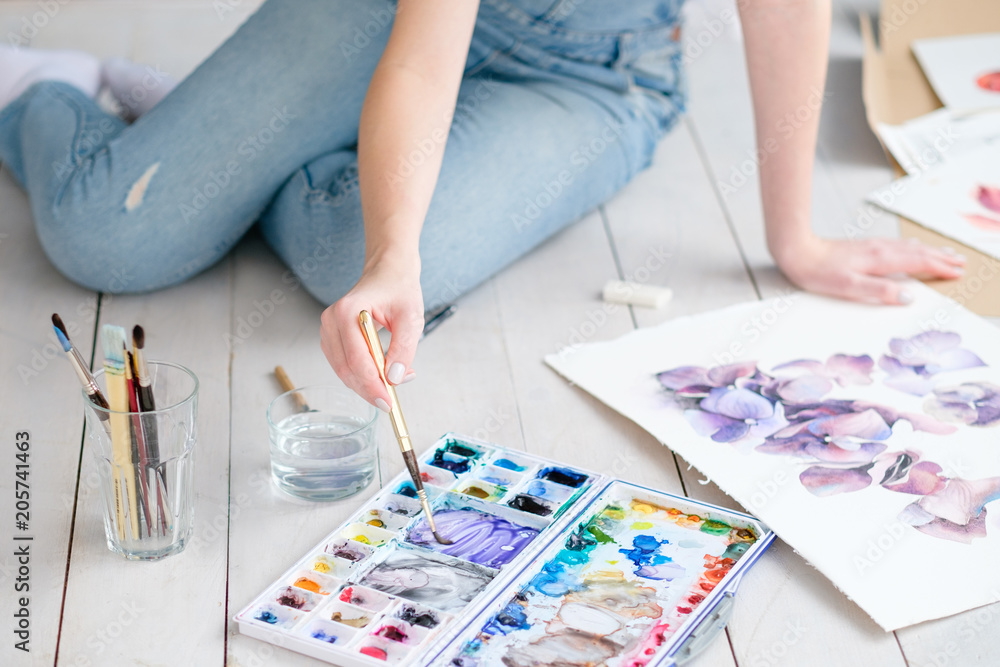 art craft and creativity. painter at work. woman mixing watercolors when drawing a beautiful floral picture