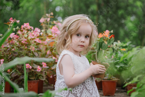 girl plays with flowers in the greenhouse © Татьяна Скорина