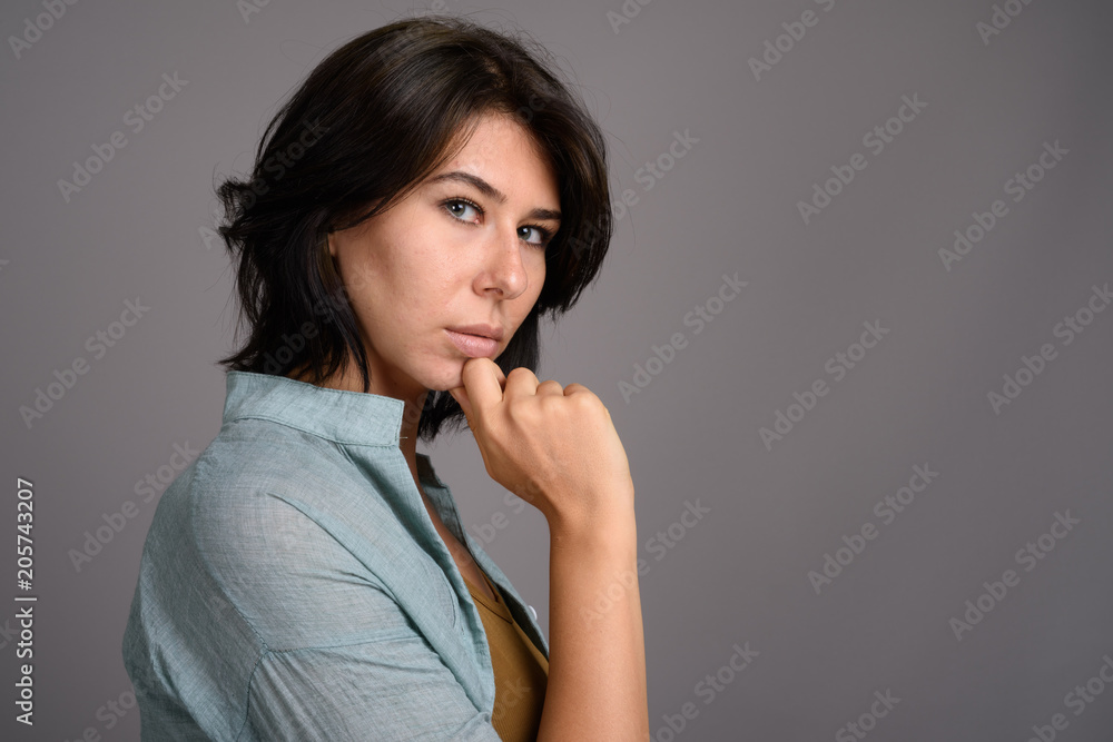 Young beautiful woman against gray background
