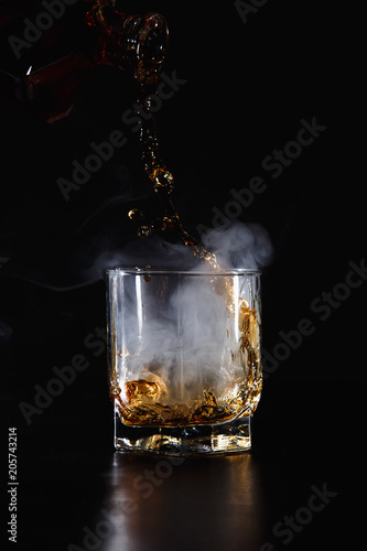 a glass of whiskey, rum or alcohol  on a dark background