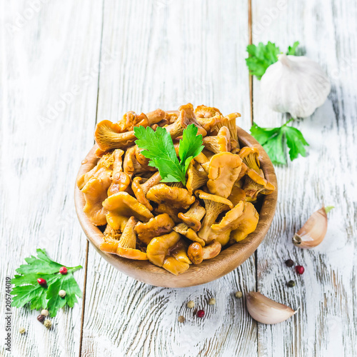 Pickled chanterelle mushrooms on wooden bowl on rustic background. Selctive focus, space for text.