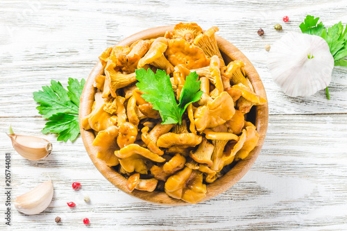 Marinated chanterelle mushrooms on wooden bowl on rustic background. Top view  space for text.