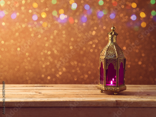 Lightened lantern on wooden table photo