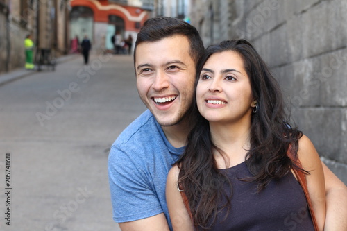 Beautiful latino couple smiling while looking away