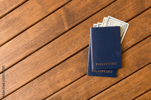 Passports with banknotes of dollars on a wooden table . The concept of tourism. Empty text space