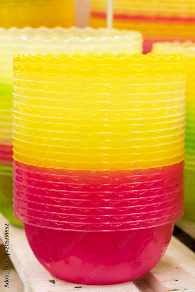 Plastic multi-colored bowls on the shelf in the store Plastic multi-colored bowls on the shelf in the store