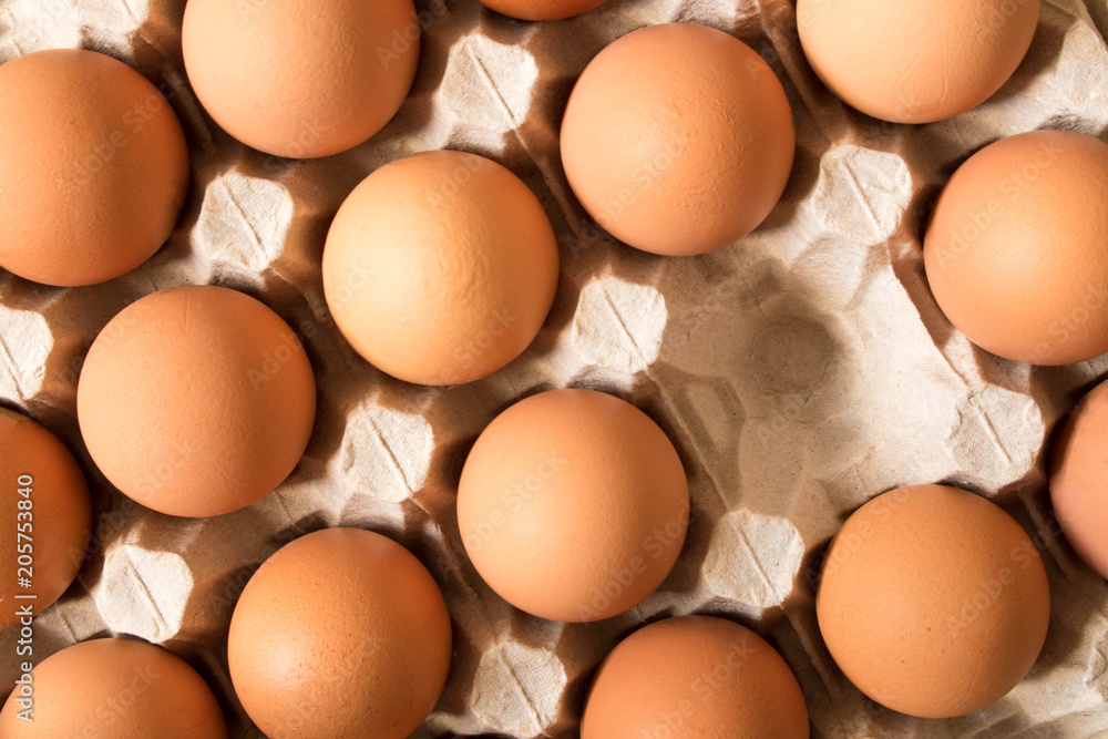 Background of large chicken eggs in a cardboard box with empty space . Close up Background of large chicken eggs in a cardboard box with empty space . Close up