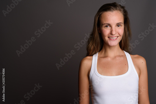 Young beautiful woman with long blond hair against gray backgrou