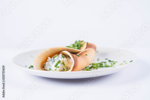 Pancake with cottage cheese and chives decorated with basil