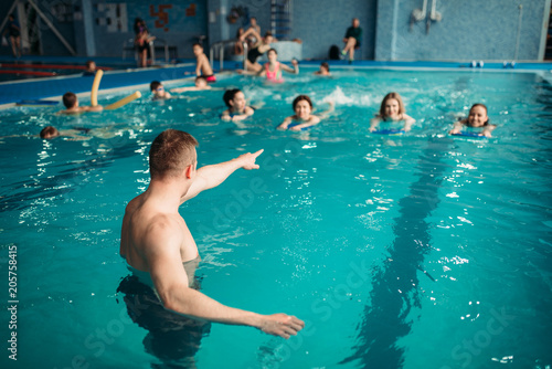 Instructor works with class in swimming pool