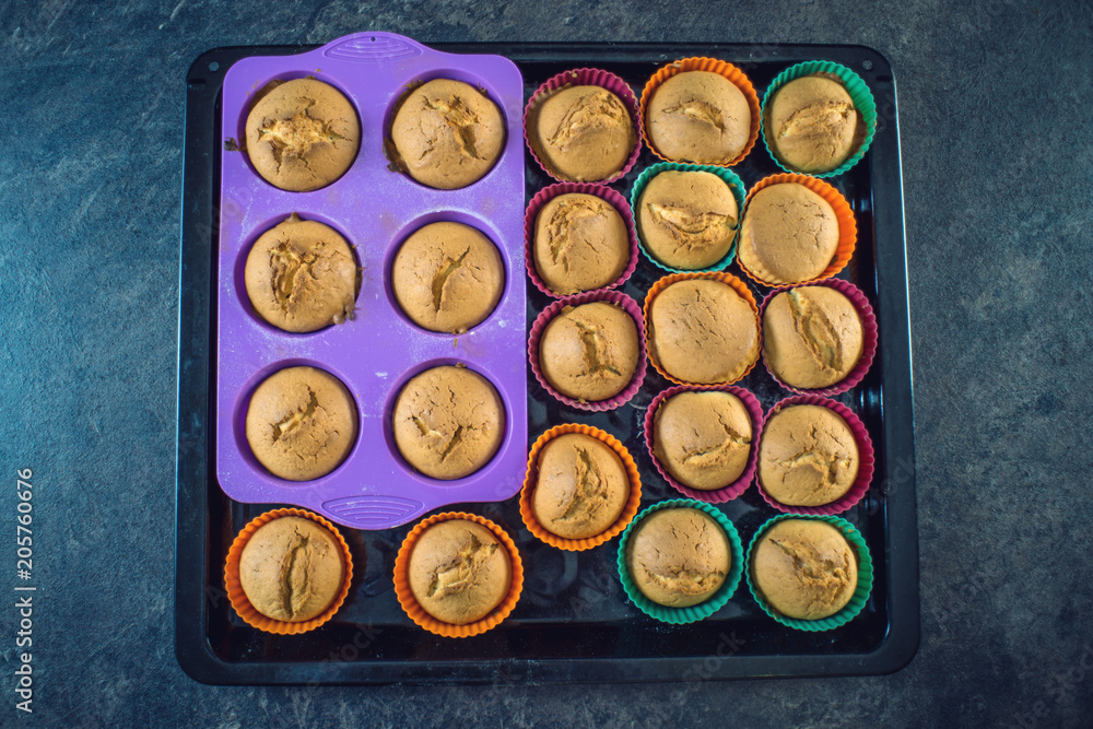 Homemade freshly made cupcakes in silicone molds on dark background. Top view. Concept of confectionery cooking