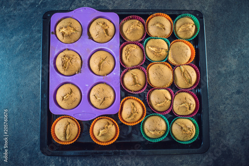 Homemade freshly made cupcakes in silicone molds on dark background. Top view. Concept of confectionery cooking
