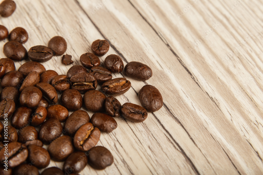 Grains of coffee on a wooden background in large quantities Grains of coffee on a wooden background in large quantities