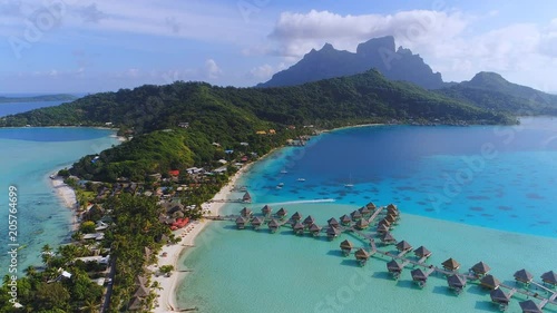 Aerial view of tropical paradise of Bora Bora island, turquoise crystal clear water of scenic blue lagoon, typical over water bungalows, Matira Point - South Pacific Ocean, French Polynesia from above photo