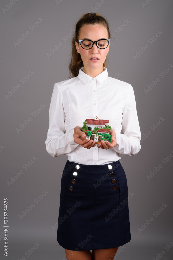 Young beautiful businesswoman against gray background Young beautiful businesswoman against gray background