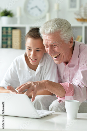 portrait of boy and grandfather with a laptop