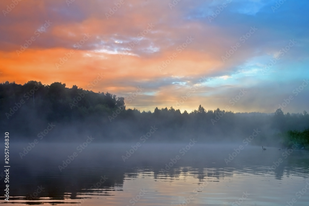  sunrise in beautiful pink and blue colors over the river in the fog
