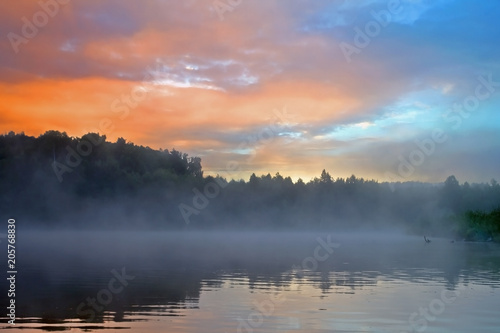  sunrise in beautiful pink and blue colors over the river in the fog
