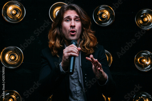 Brutal singer with long hair, with microphone on the stage © Skripnik Olga