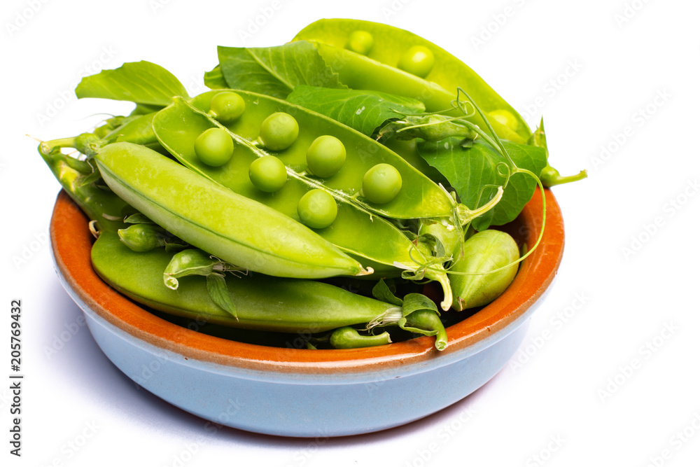 Fresh green ripe sugar snaps, sweet peas in bowl copy space close up isolated on white background Fresh green ripe sugar snaps, sweet peas in bowl copy space close up isolated on white background