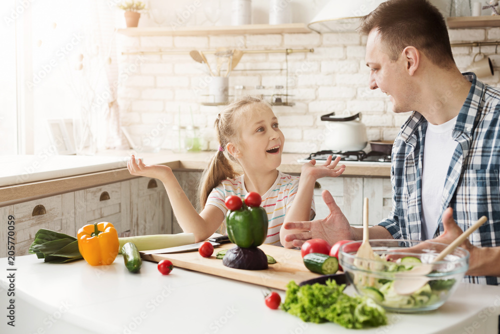 Little girl and dad having fun while cooking in kitchen Little girl and dad having fun while cooking in kitchen