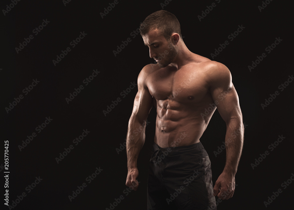 Strong athletic man showes naked muscular body Strong athletic man showes naked muscular body