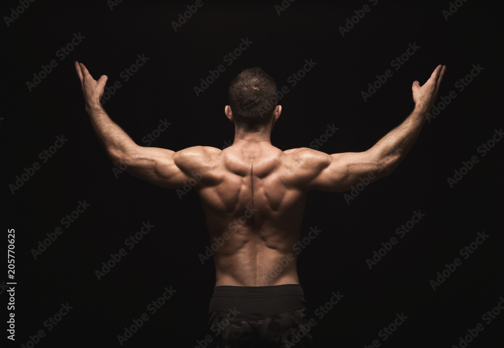 Fototapeta premium Unrecognizable man shows strong back muscles closeup