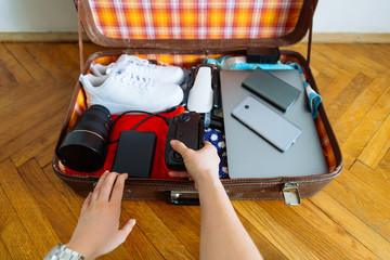 valise with gadgets and wear inside. travel concept. overtop view
