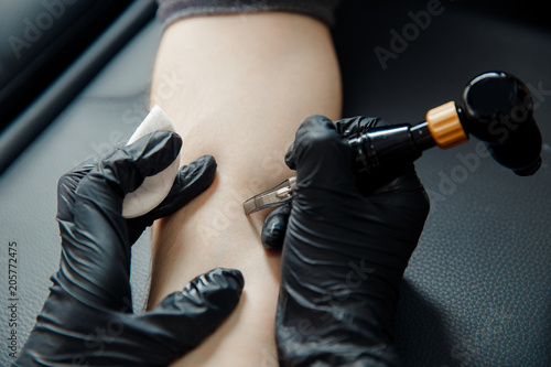 tattoo process machine close-up. master prepares for procedure of drawing