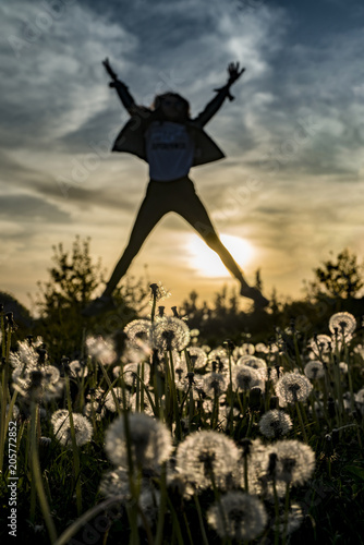 Young happy girl jumping at sunset