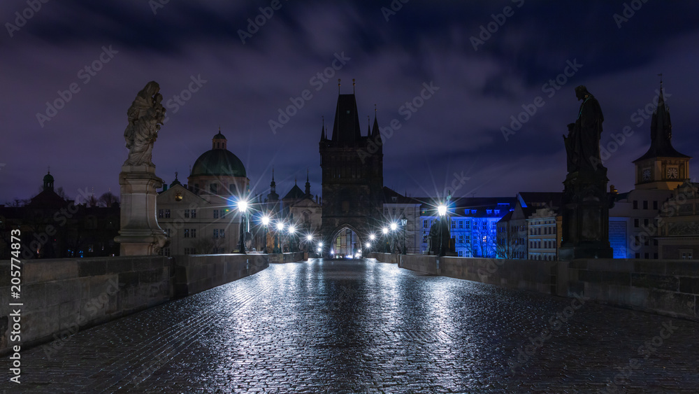 Karlsbrücke in Prag über die Moldau bei Nacht. Dämmerung mit nassem Kopfsteinpflasterboden