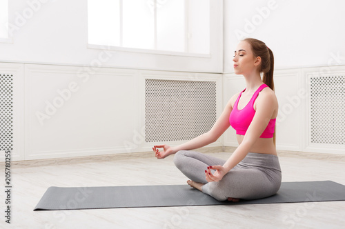 Woman training yoga in lotus pose.