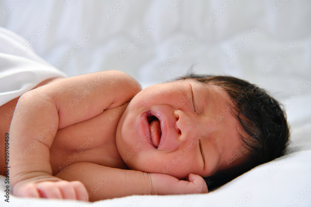 Newborn Concept. Newborn babies are sleeping in a bed. The baby is in the white bedroom. Newborn Concept. Newborn babies are sleeping in a bed. The baby is in the white bedroom.