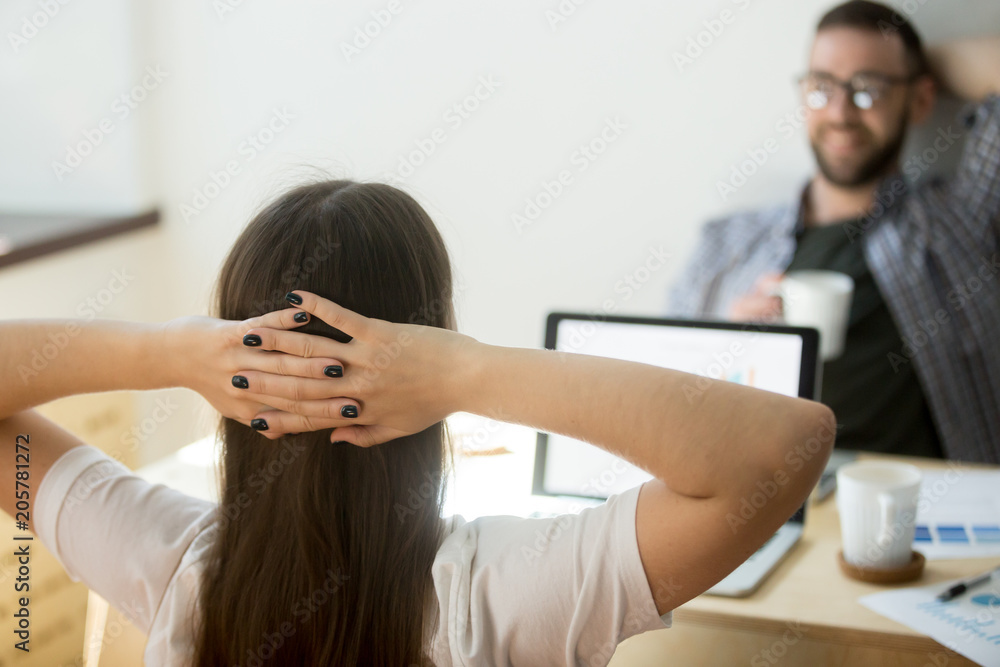 Close up back view of female freelance worker resting hands over head, relaxing in chair after successful online business deal, reading good news, finishing difficult project, solving problem. Reward Close up back view of female freelance worker resting hands over head, relaxing in chair after successful online business deal, reading good news, finishing difficult project, solving problem. Reward