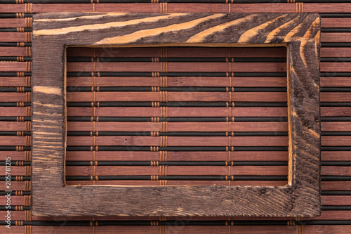 Rectangular wooden frame on a bamboo mat.