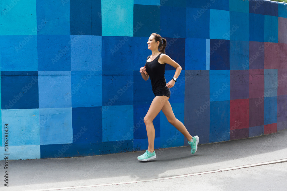 Side view of woman running against bright wall Side view of woman running against bright wall