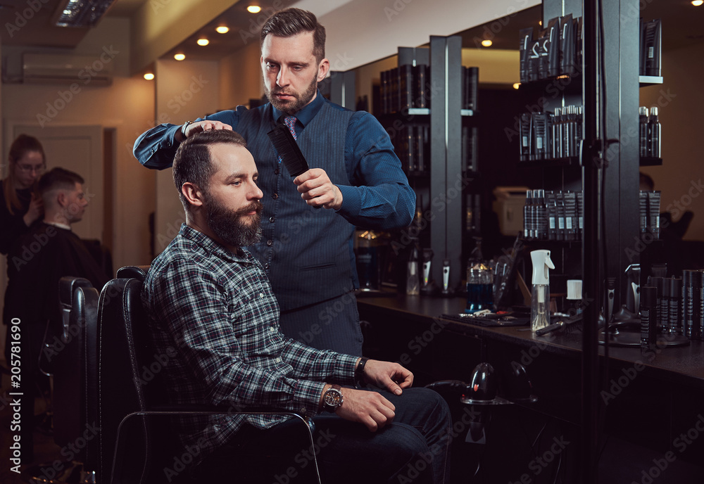 Fototapeta premium Professional barber working with a client in a hairdressing salon.