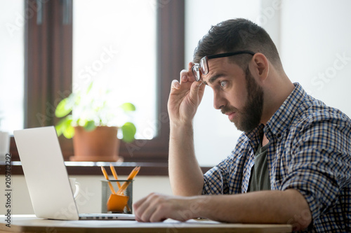 Canvas Print Shocked frustrated male staring at laptop screen, upset with bad online news, company business collapse, shares depreciation, rates decreasing