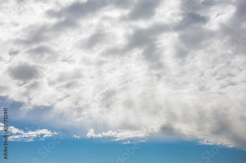 Fototapeta Naklejka Na Ścianę i Meble -  Sun rays shinning in the blue sky with layer of clouds.