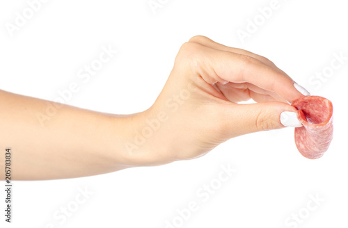 A slice of sausage in hand on a white background isolated