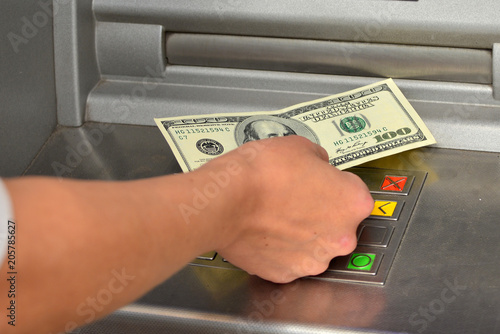 The person's hand receives money, dollars from the ATM, the concept of banks, finance and people