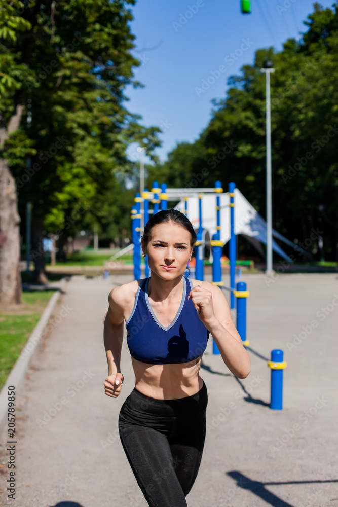 Young beautiful teen in a bright blue sport bra and black leggings running  on the sport playground. Photo of an athlete girl with a beautiful sports  body Photos | Adobe Stock