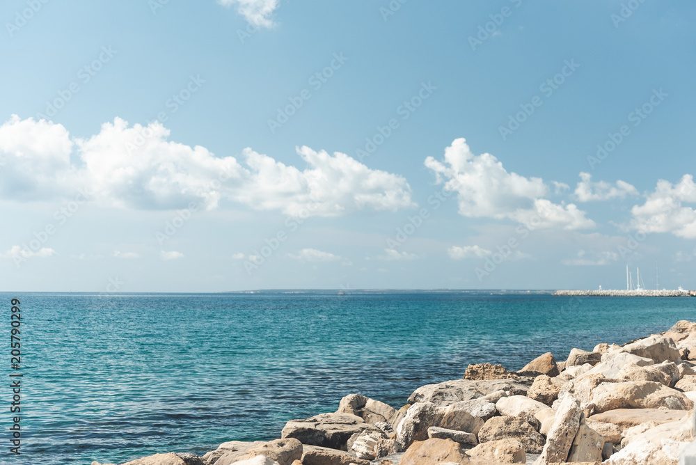 Blue sky with white fluffy clouds locating over blue sea. Landscape concept