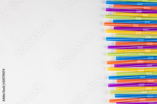 Multicolored strawberries for drinking on a white background  straw