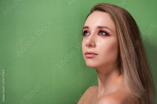 Beautiful young girl on a green background.