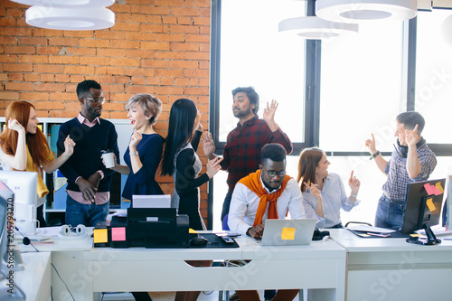 hardworking Afro office manager is doing his job while his partners are hanging on in the loft room. working in difficult situation