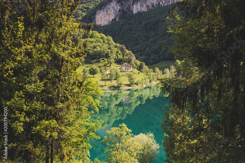 Lago di tenno with mountain and trees reflection in water. Tenno  Privincia di Trento  Trentino0Alto Adige  Italy