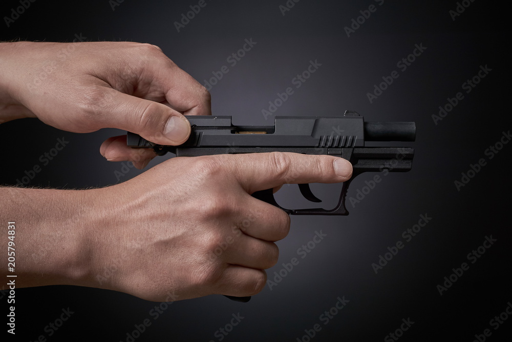 reloading a handgun, pulling back slide, side view reloading a handgun, pulling back slide, side view