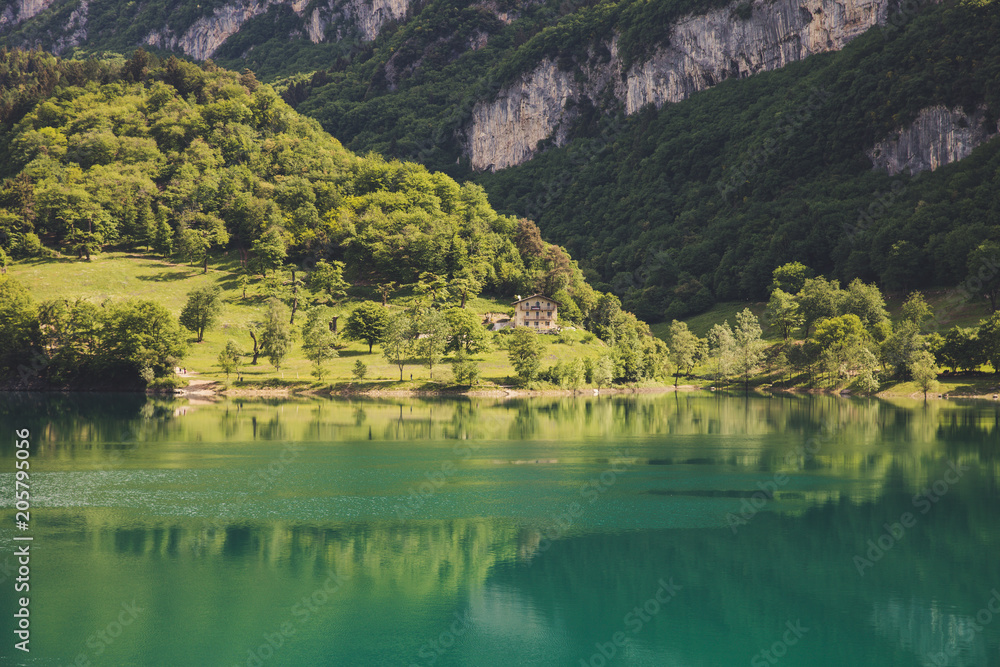 Lago di tenno with mountain and trees reflection in water. Tenno, Privincia di Trento, Trentino0Alto Adige, Italy Lago di tenno with mountain and trees reflection in water. Tenno, Privincia di Trento, Trentino0Alto Adige, Italy